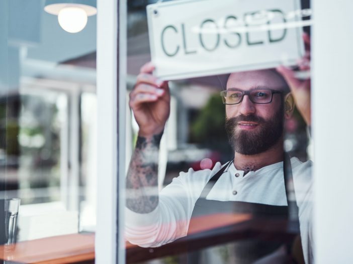 Customer sitting in a restaurant after hours, enjoying their time while staff tidies up