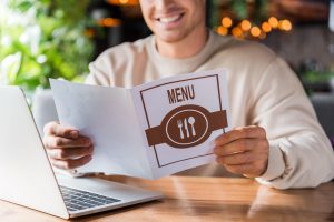 Restaurant staff serving menus to a group of customers after a long wait