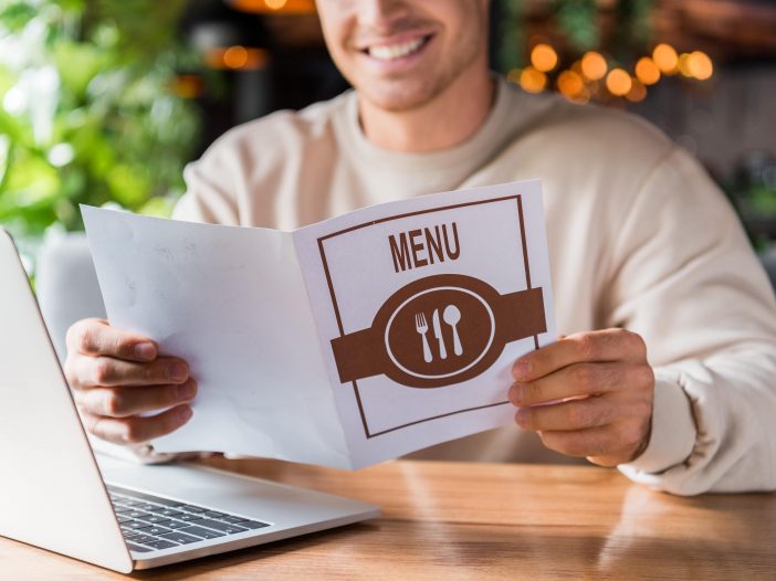 Restaurant staff serving menus to a group of customers after a long wait