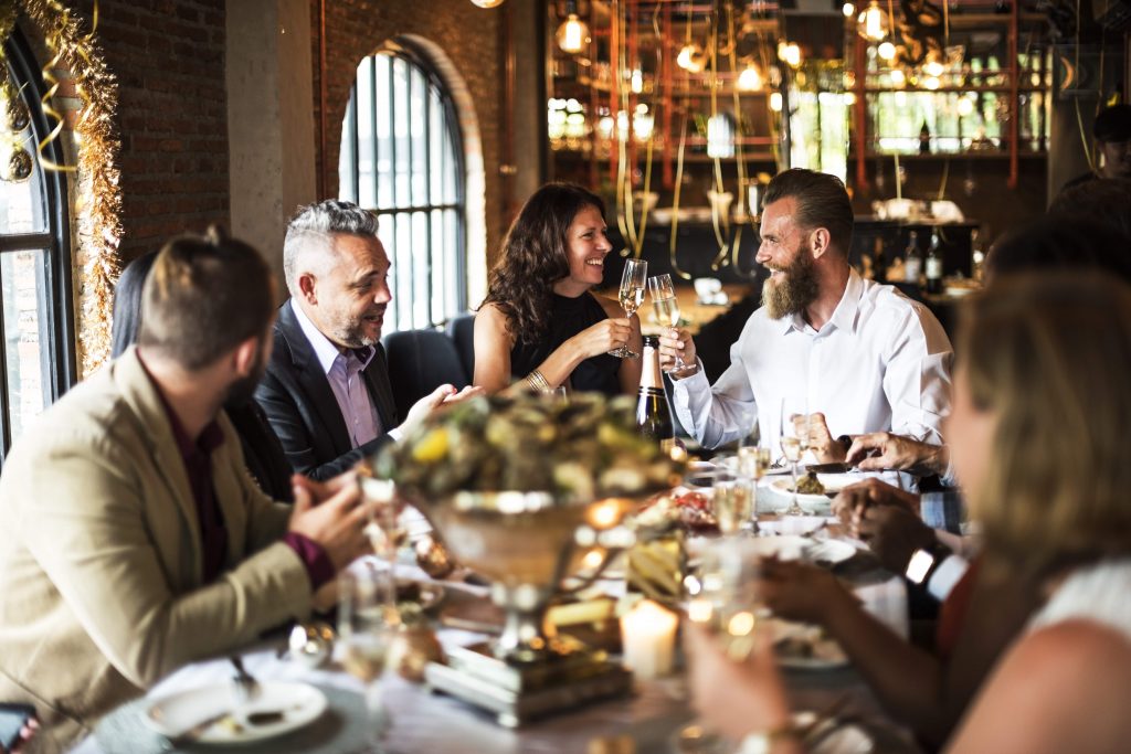 Chef preparing gourmet dishes in an open kitchen, with customers observing for an exclusive dining experience.