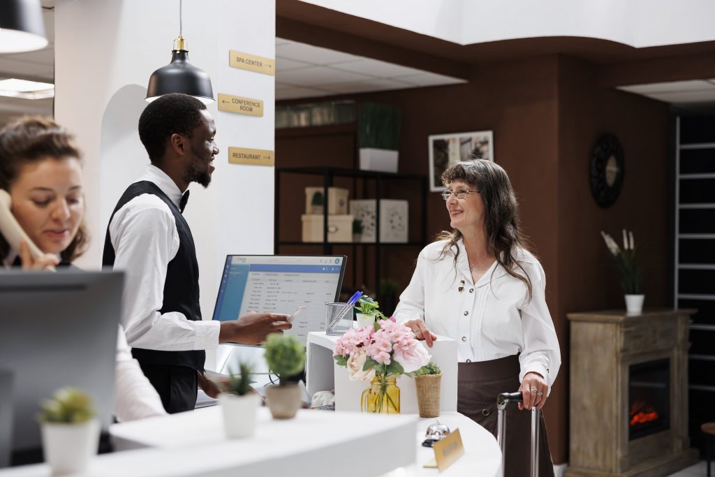 Hotel front desk with a receptionist assisting a guest